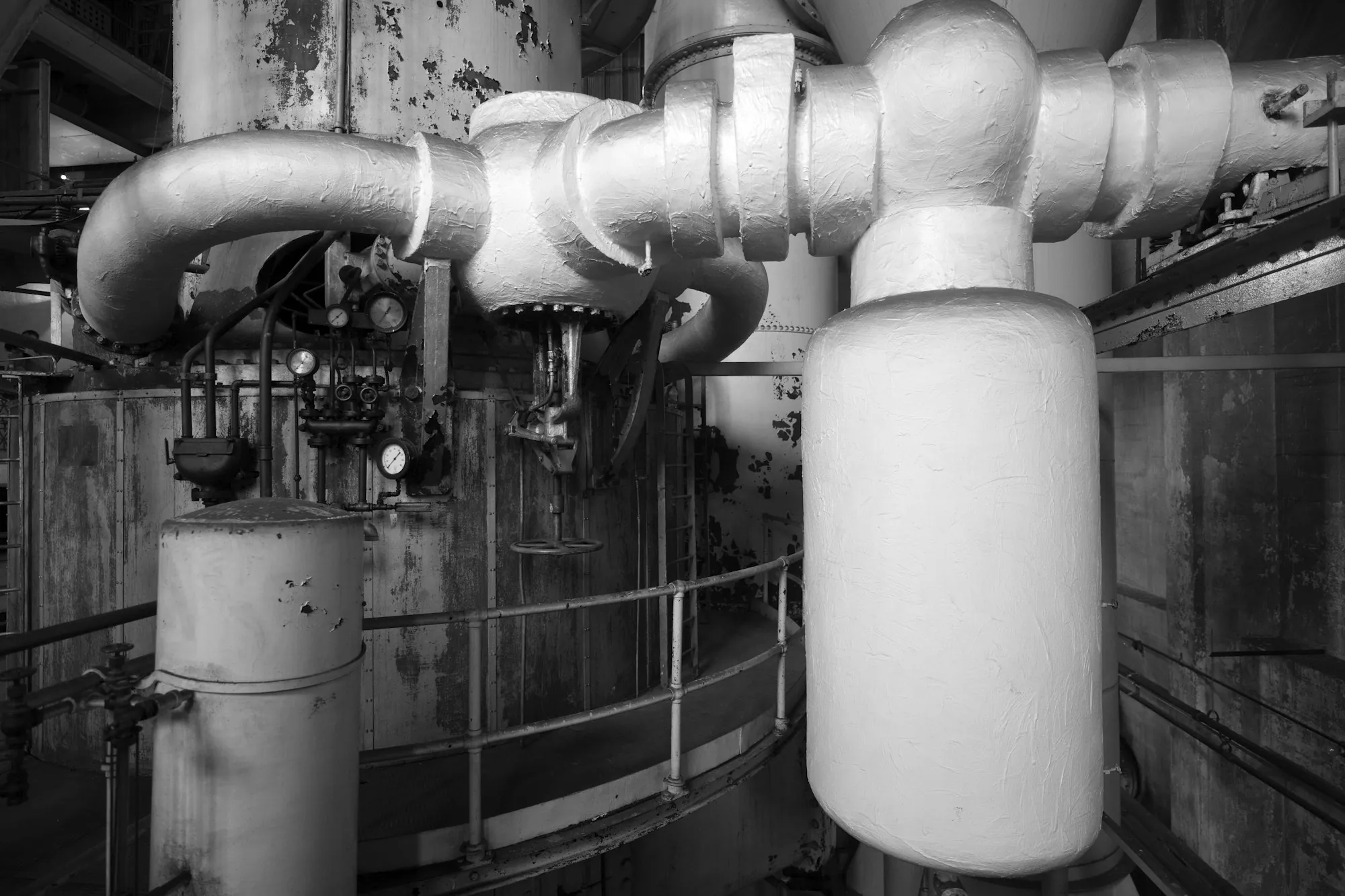 Black and white view of a boiler room with pipes