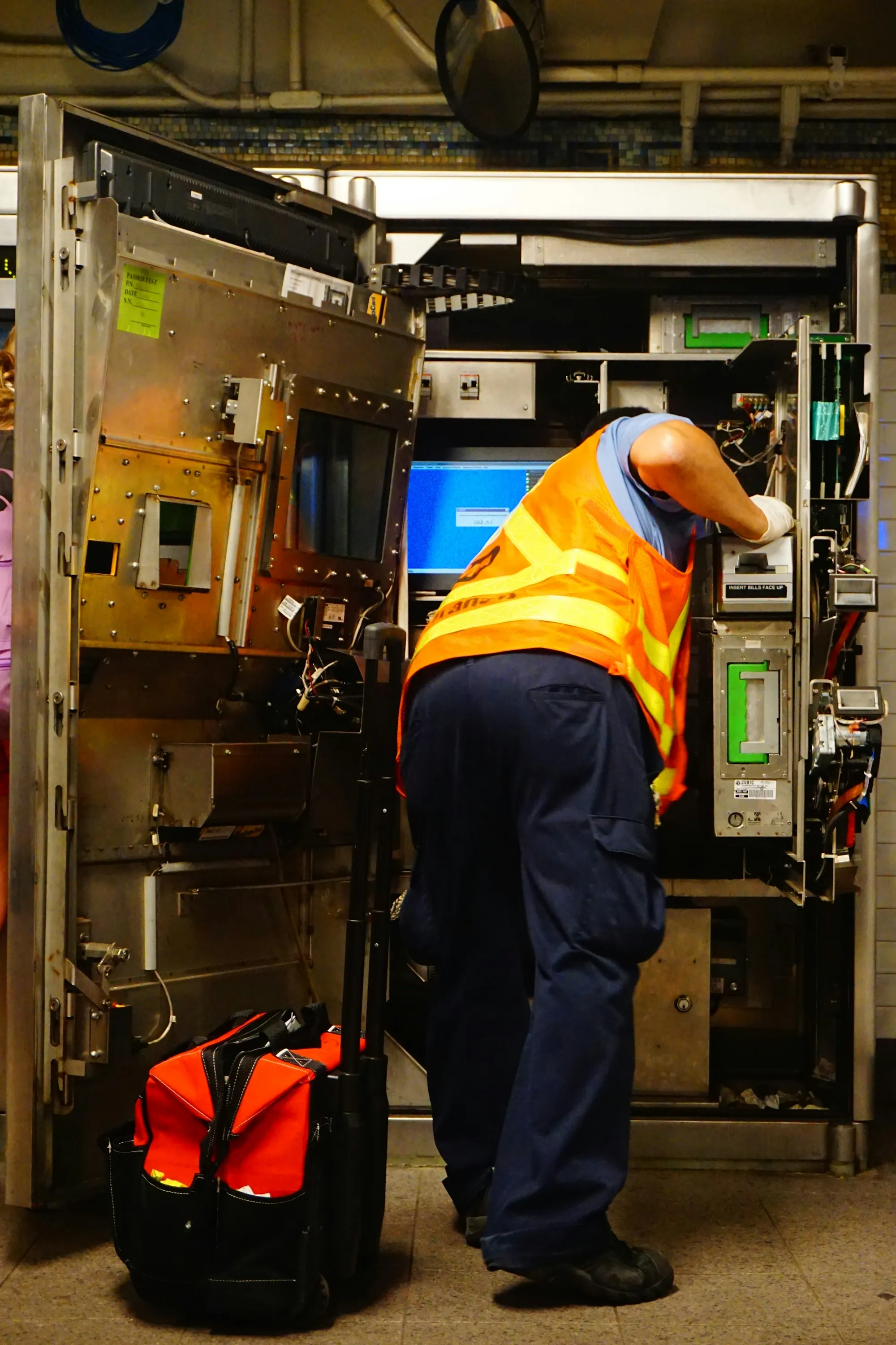 Worker in a hi-vis vest servicing equipment cabinets