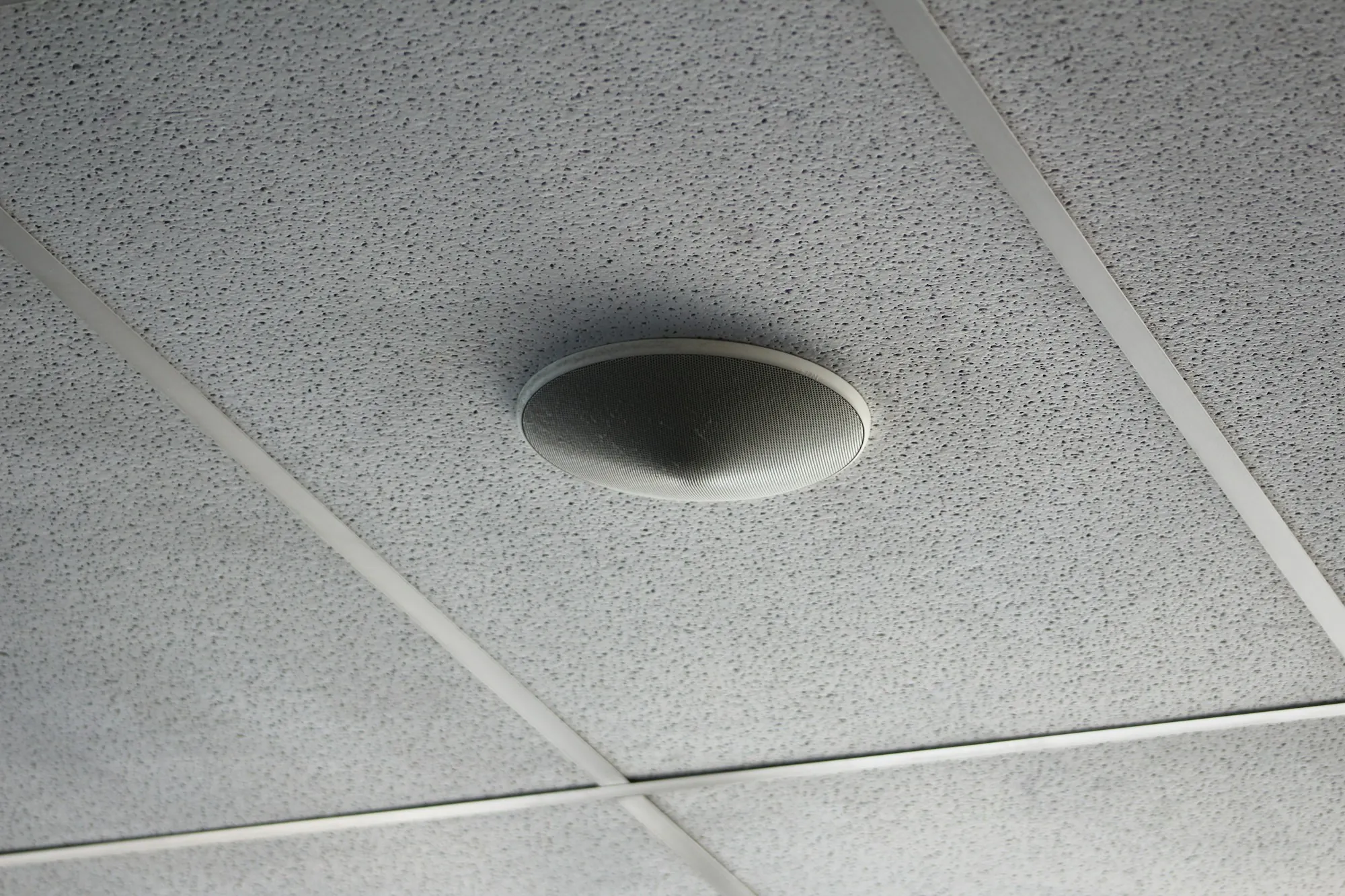 Round ceiling diffuser in an acoustic tile ceiling